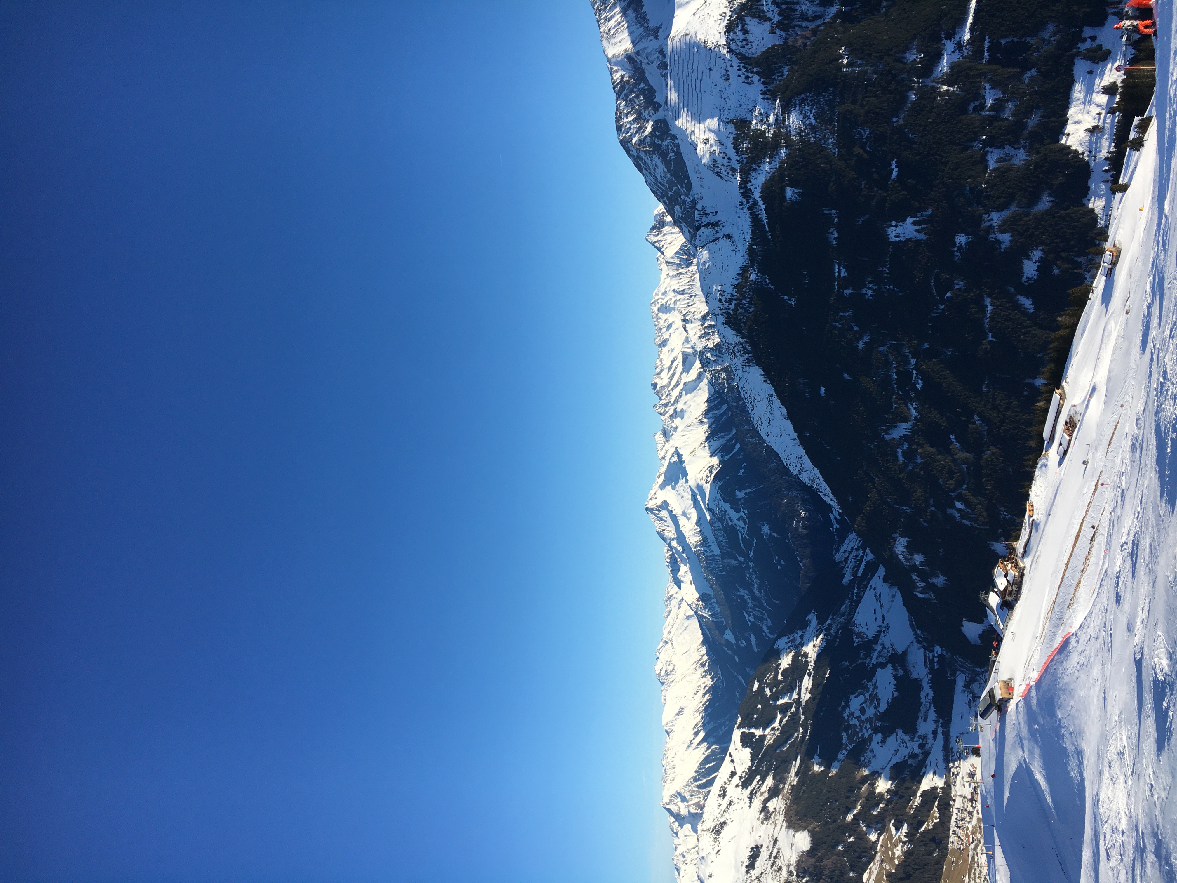 A vast snow-covered mountain panorama under a wide sky
